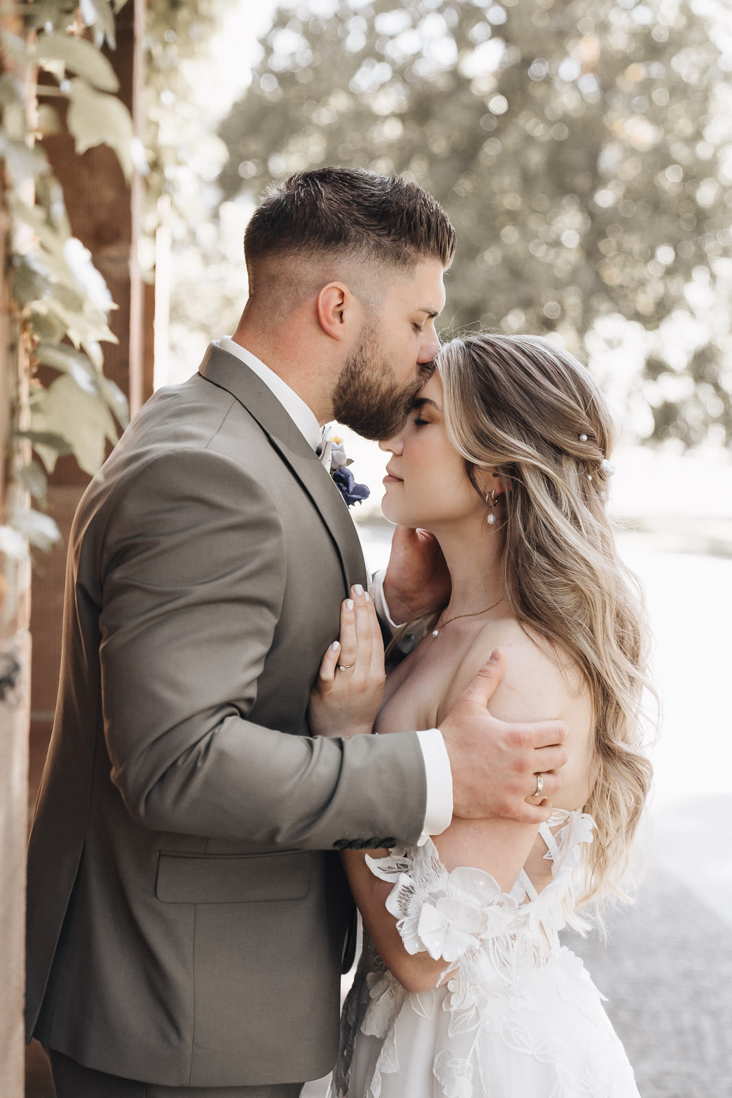 Bräutigam küsst Braut zart auf die Stirn