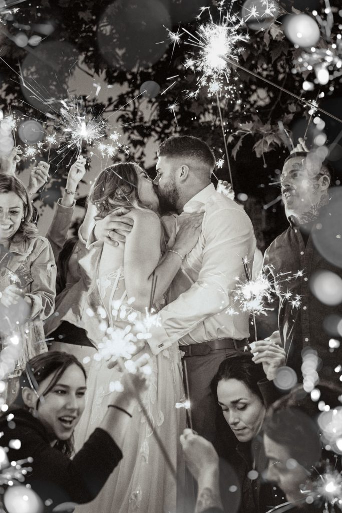 Brautpaar küsst sich die Gäste stehen mit Wunderkerzen drum herum und feiern. Hochzeitsfotograf Saarland Mona Fotografie