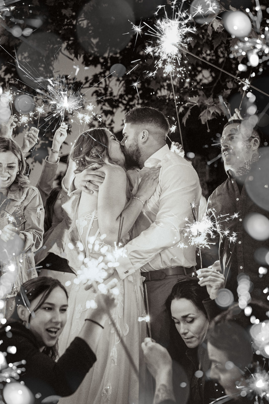 Brautpaar küsst sich die Gäste stehen mit Wunderkerzen drum herum und feiern. Hochzeitsfotograf Saarland Mona Fotografie